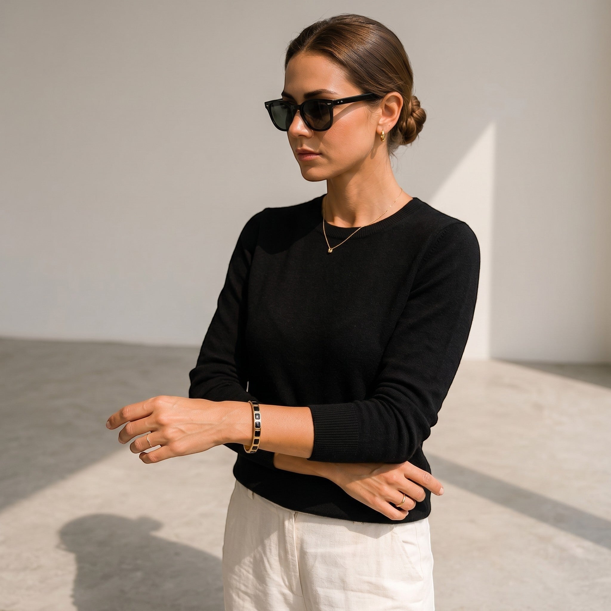 Mein Shop gold and black stainless steel bamboo design adjustable bangle bracelet on a woman's wrist.