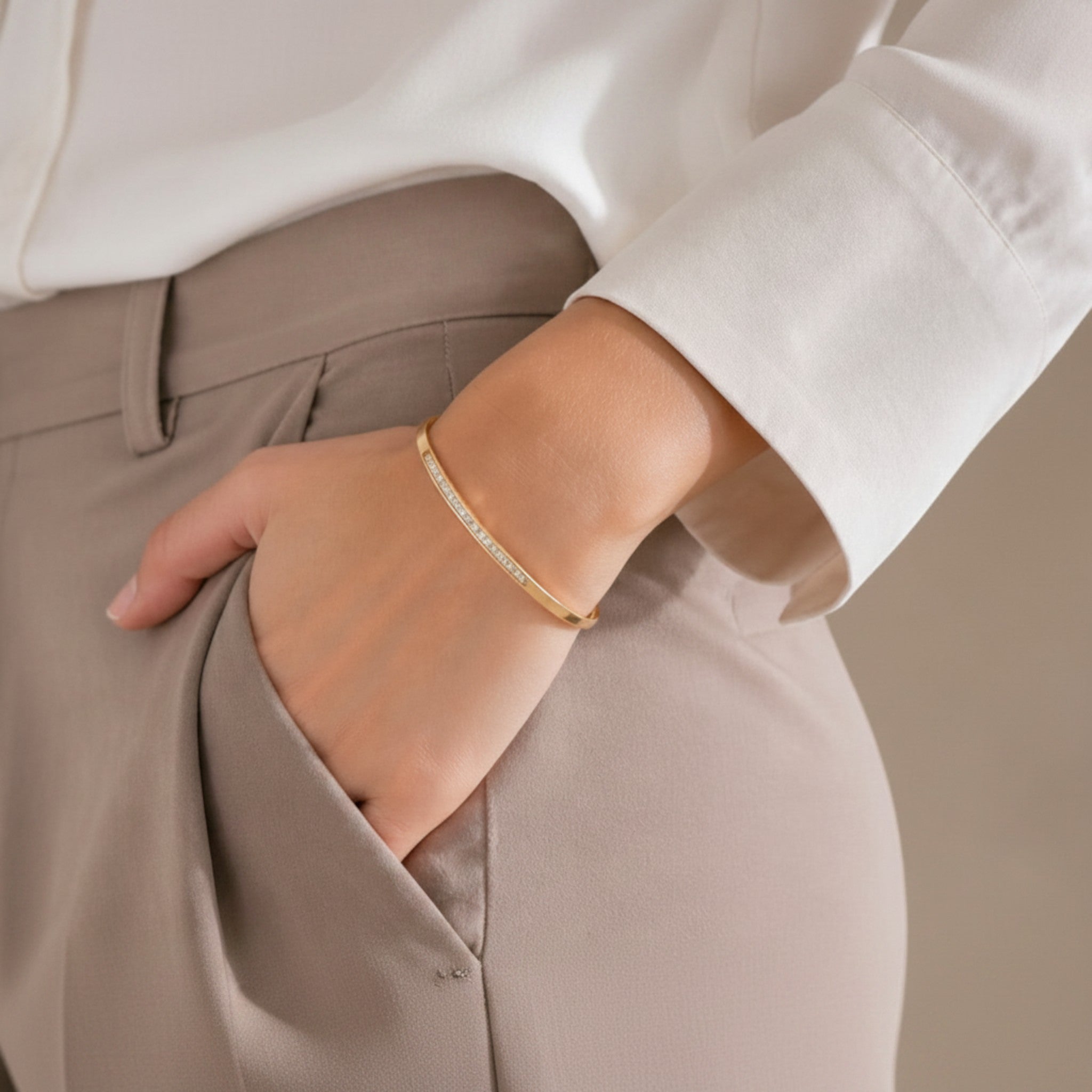 Mein Shop gold-tone bangle bracelet with clear crystals, worn on a woman's wrist.